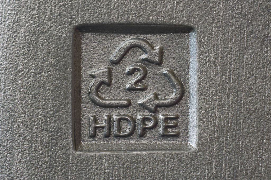 recycling symbol with 2 HDPE molded on textured plastic surface, icon with important instructions for recyclability
