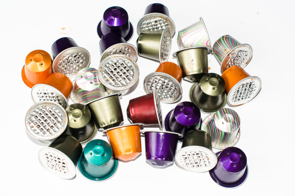 Colourful used gourmet coffe capsules on a bright reflective background